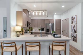 An open kitchen with a large island with three stools